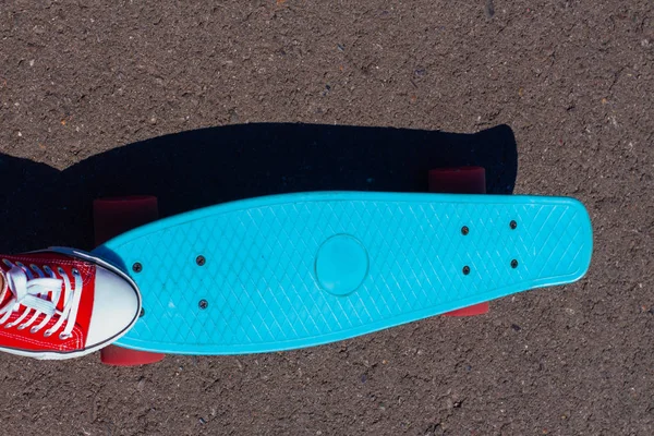 Gros plan des pieds et planche à roulettes bleu penny avec roues roses . — Photo
