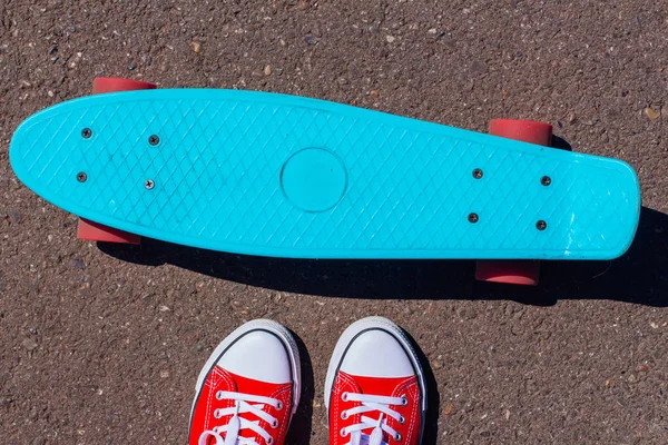 Gros plan des pieds et planche à roulettes bleu penny avec roues roses . — Photo