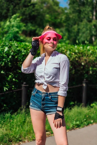 Retrato de una chica emocional con una visera de gorra rosa y protector — Foto de Stock