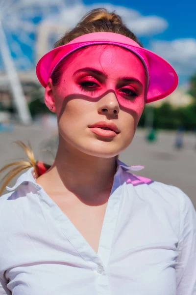 Retrato de una chica emocional con una visera de gorra rosa y protector — Foto de Stock