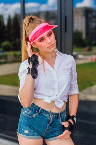 Πορτραίτο ενός συναισθηματικού κοριτσιού σε ένα ροζ καπάκι και προστατευτικά γάντια για πατίνια και σκέιτμπορντ. — Φωτογραφία Αρχείου