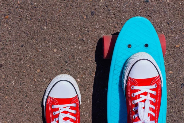 Nahaufnahme von Füßen und blauem Penny-Skateboard mit rosa Rädern. — Stockfoto