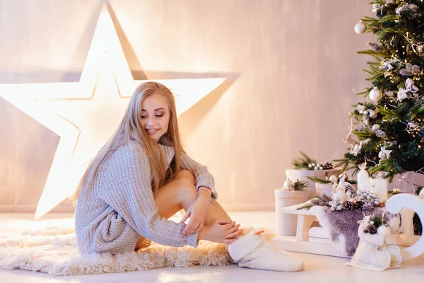 Vacker ung kvinna poserar julen i en semester interiör — Stockfoto