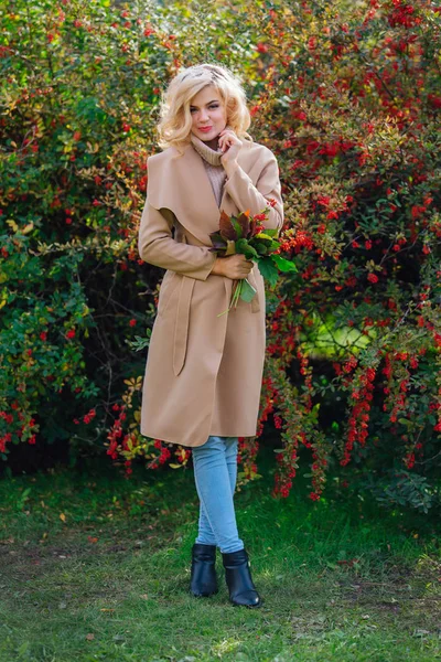 Sonbahar parkta sonraki karamuk Bush ayakta güzel zarif kadın