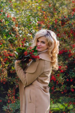 Sonbahar parkta sonraki karamuk Bush ayakta güzel zarif kadın