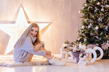 Bir tatil iç Noel ağacı altında poz güzel genç kadın
