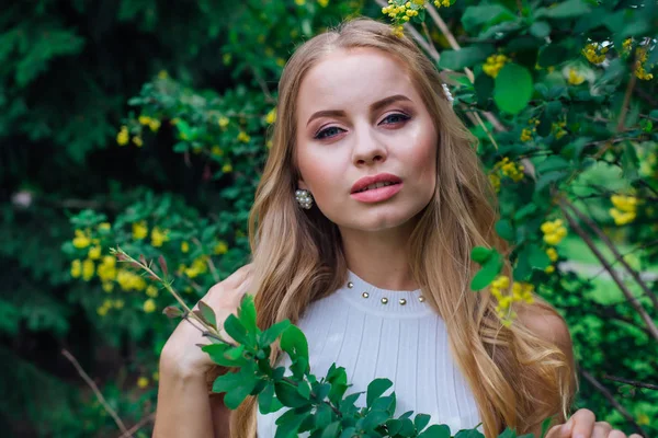 Close-up portret van een charmante blonde vrouw het dragen van mooie witte jurk staan naast Berberis Bush. — Stockfoto