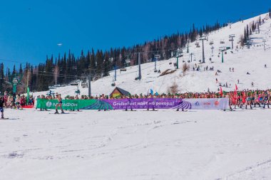 Sheregesh, Kemerovo bölgesi, Rusya - 13 Nisan 2019: Yokuşta snowboard ve dağ kayağı yapan bikinili ve şortlu bir kalabalık