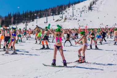 Sheregesh, Kemerovo bölgesi, Rusya - 13 Nisan 2019: Yokuşta snowboard ve dağ kayağı yapan bikinili ve şortlu bir kalabalık