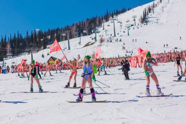 Sheregesh, Kemerovo bölgesi, Rusya - 13 Nisan 2019: Yokuşta snowboard ve dağ kayağı yapan bikinili ve şortlu bir kalabalık