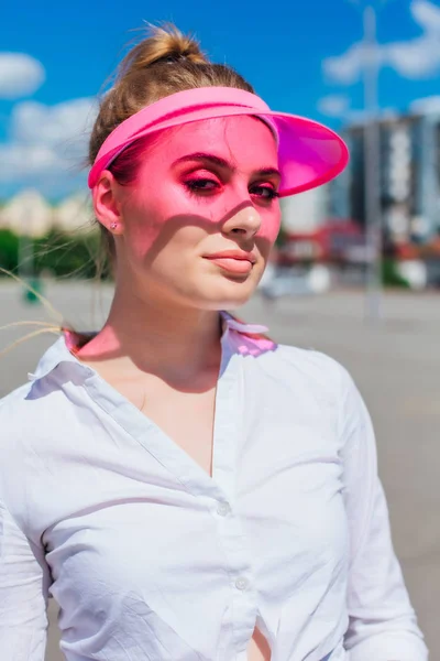 Retrato de una chica emocional con una visera de gorra rosa y protector — Foto de Stock