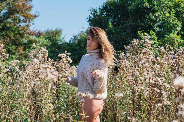 Felice giovane bella donna in maglione e mutande a piedi nudi in un campo di agrimonia secca — Foto Stock