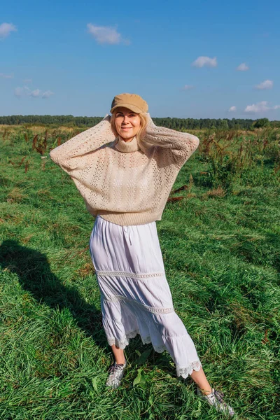 Feliz bela mulher loira andando em um campo verde — Fotografia de Stock