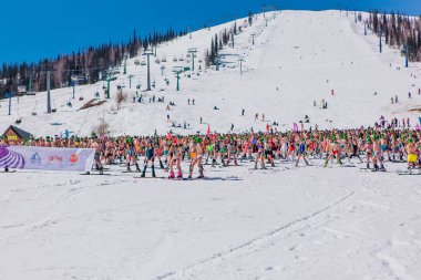 Sheregesh, Kemerovo bölgesi, Rusya - 13 Nisan 2019: Yokuşta snowboard ve dağ kayağı yapan bikinili ve şortlu bir kalabalık