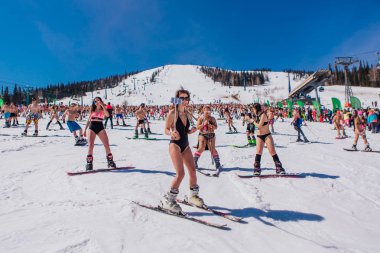 Sheregesh, Kemerovo bölgesi, Rusya - 13 Nisan 2019: Yokuşta snowboard ve dağ kayağı yapan bikinili ve şortlu bir kalabalık