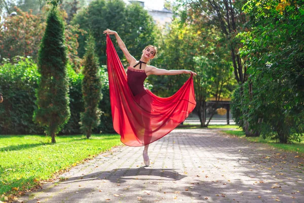 가을 공원에서 붉은 발레 드레스를 입은 발레리나 가프 린 테 신발을 신고 춤을 추는 모습. — 스톡 사진