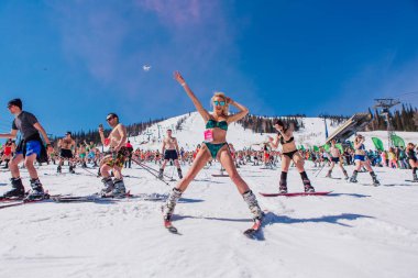 Sheregesh, Kemerovo bölgesi, Rusya - 13 Nisan 2019: Yokuşta snowboard ve dağ kayağı yapan bikinili ve şortlu bir kalabalık