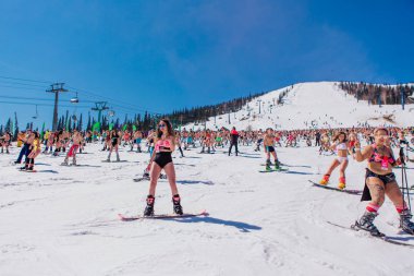 Sheregesh, Kemerovo bölgesi, Rusya - 13 Nisan 2019: Yokuşta snowboard ve dağ kayağı yapan bikinili ve şortlu bir kalabalık