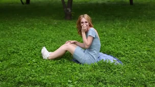 曇り空の日に公園で草の上に寝そべっている若い美しい十代の女の子、笑顔、リラックスしたコンセプト、夢のコンセプト — ストック動画