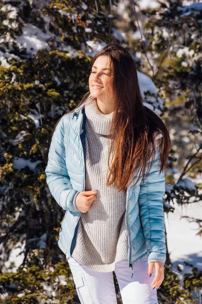 Portré egy fiatal gyönyörű barna nő kék szemek és szeplők az arcon a téli havas hegyi táj. Gyönyörű lány télen a szabadban. — Stock Fotó
