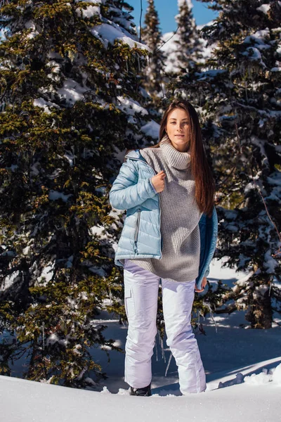 Retrato de uma jovem bela mulher morena com olhos azuis e sardas no rosto no inverno paisagem de montanha nevada. Menina bonita no inverno ao ar livre . — Fotografia de Stock