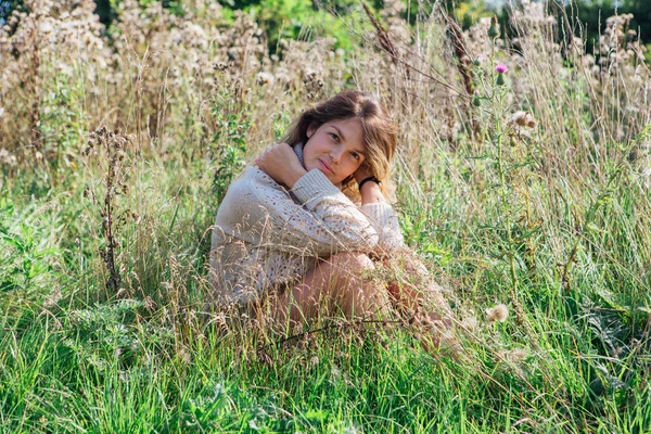 Felice giovane bella donna in maglione e mutande seduta a piedi nudi in un campo di agrimonia secca — Foto Stock