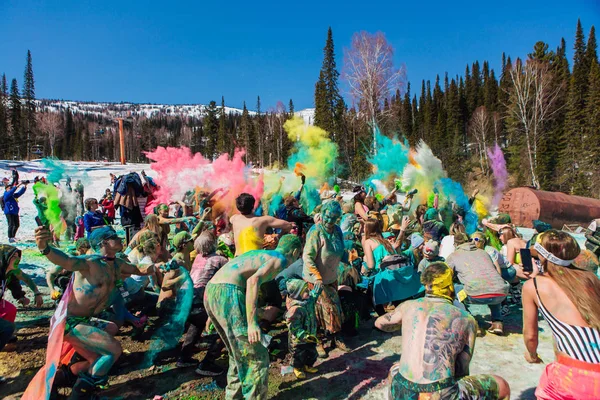 Sheregesh, región de Kemerovo, Rusia - 13 de abril de 2019: Un grupo de jóvenes lanzando coloridos holis en polvo . — Foto de Stock