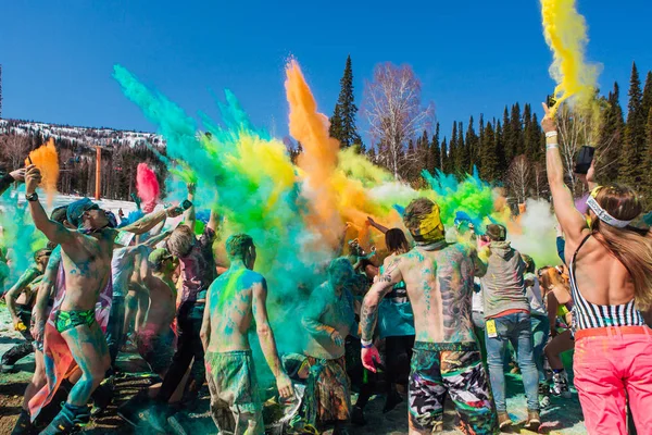 Sheregesh, región de Kemerovo, Rusia - 13 de abril de 2019: Un grupo de jóvenes lanzando coloridos holis en polvo . — Foto de Stock