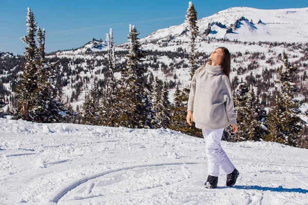 Retrato de una joven hermosa morena con ojos azules y pecas en la cara en invierno nevado paisaje de montaña. Hermosa chica en el invierno al aire libre . — Foto de Stock