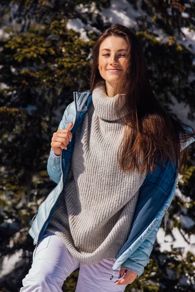 Retrato de uma jovem bela mulher morena com olhos azuis e sardas no rosto no inverno paisagem de montanha nevada. Menina bonita no inverno ao ar livre . — Fotografia de Stock