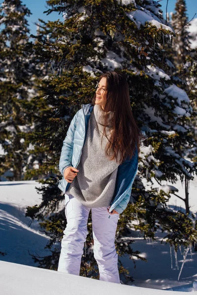 Porträtt av en ung vacker brunett kvinna med blå ögon och fräknar i ansiktet i vinter snöiga bergslandskap. Vacker flicka på vintern utomhus. — Stockfoto
