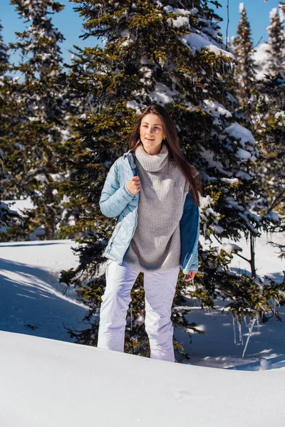 Porträtt av en ung vacker brunett kvinna med blå ögon och fräknar i ansiktet i vinter snöiga bergslandskap. Vacker flicka på vintern utomhus. — Stockfoto