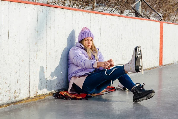 Krásná mladá žena sedí na ledovém prstenu a tkaničky — Stock fotografie