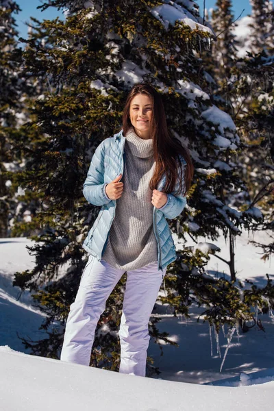 Retrato de uma jovem bela mulher morena com olhos azuis e sardas no rosto no inverno paisagem de montanha nevada. Menina bonita no inverno ao ar livre . — Fotografia de Stock