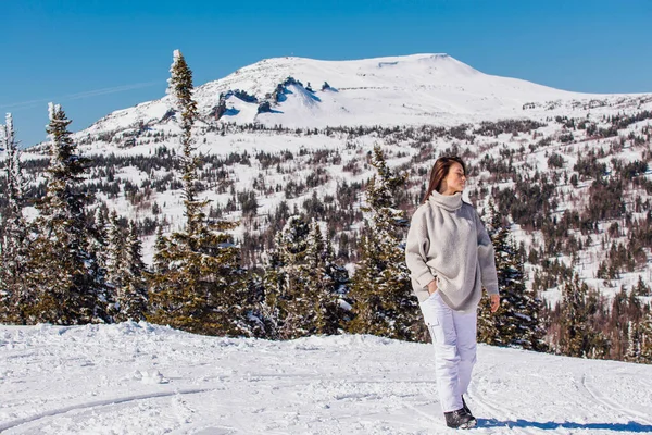 Retrato de una joven hermosa morena con ojos azules y pecas en la cara en invierno nevado paisaje de montaña. Hermosa chica en el invierno al aire libre . — Foto de Stock