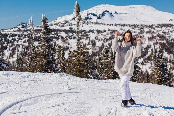 Retrato de uma jovem bela mulher morena com olhos azuis e sardas no rosto no inverno paisagem de montanha nevada. Menina bonita no inverno ao ar livre . — Fotografia de Stock