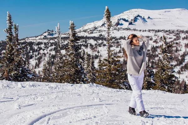 Retrato de una joven hermosa morena con ojos azules y pecas en la cara en invierno nevado paisaje de montaña. Hermosa chica en el invierno al aire libre . — Foto de Stock