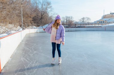 Buz pistinde buz pateni yapan hoş bir genç kadın..