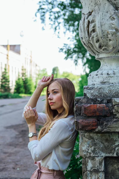 Portret van een meisje dat naast een oud gebouw staat met een decoratieve antieke vaas en trap — Stockfoto