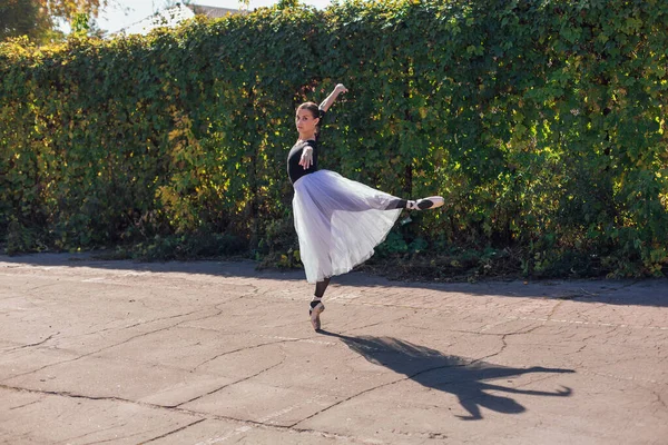 Femme ballerine dans une jupe de ballet blanc dansant en pointe chaussures dans le parc d'automne . — Photo