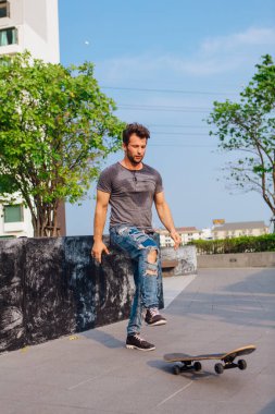 Kaykaycı kaykay numarası yapıyor. Bir şehrin caddesinde.