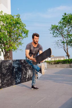 Kaykaycı kaykay numarası yapıyor. Bir şehrin caddesinde.