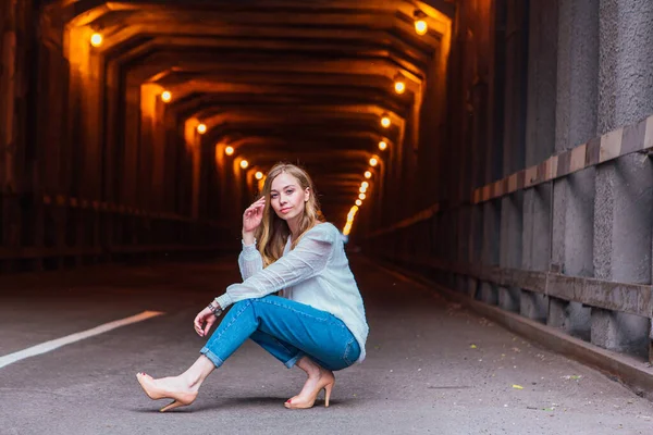 Young Woman Long Blond Hair Sitting Next Dark Industrial Tunnel — Stock Photo, Image