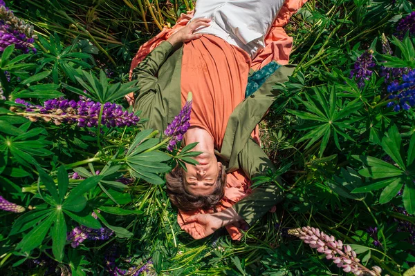 Tall Handsome Man Green Jacket Lying Lupines Flowers Top View — Stock Photo, Image