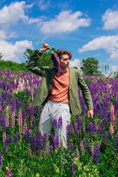 Alto Homem Bonito Uma Jaqueta Verde Campo Flores Trepadeiras Segurando — Fotografia de Stock