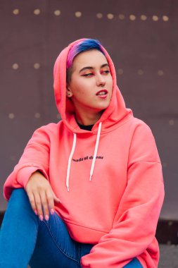 Kısa renkli saçlı ve burnu delinmiş genç bir kızın portresi.