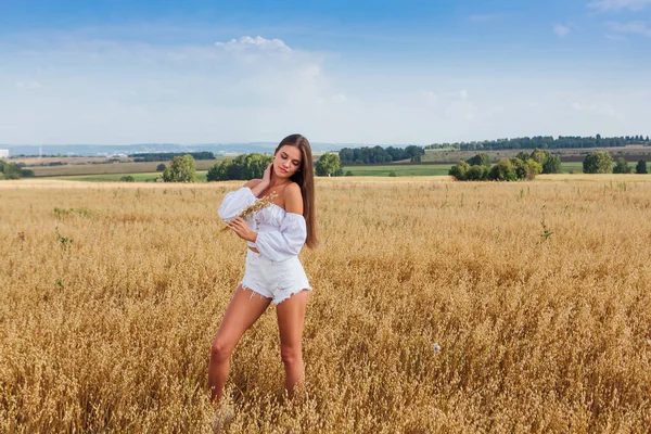 Young beautiful woman relaxing at golden oat field. — Stock Photo, Image