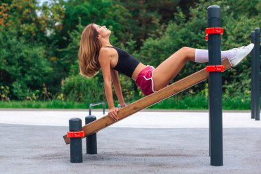 Sen güzel sarışın bir kadınsın. Çalıştığın yerdeki ahşap bir basın bankında egzersiz yapıyorsun.