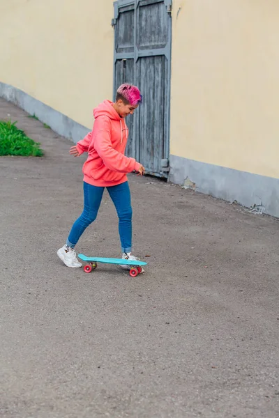 Stylowa Młoda Kobieta Krótkimi Kolorowymi Włosami Jeżdżąca Niebieską Plastikową Deskorolką — Zdjęcie stockowe