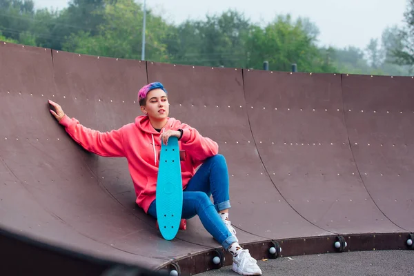 Mavi Plastik Kaykayıyla Parka Oturan Kısa Boylu Şık Bir Genç — Stok fotoğraf